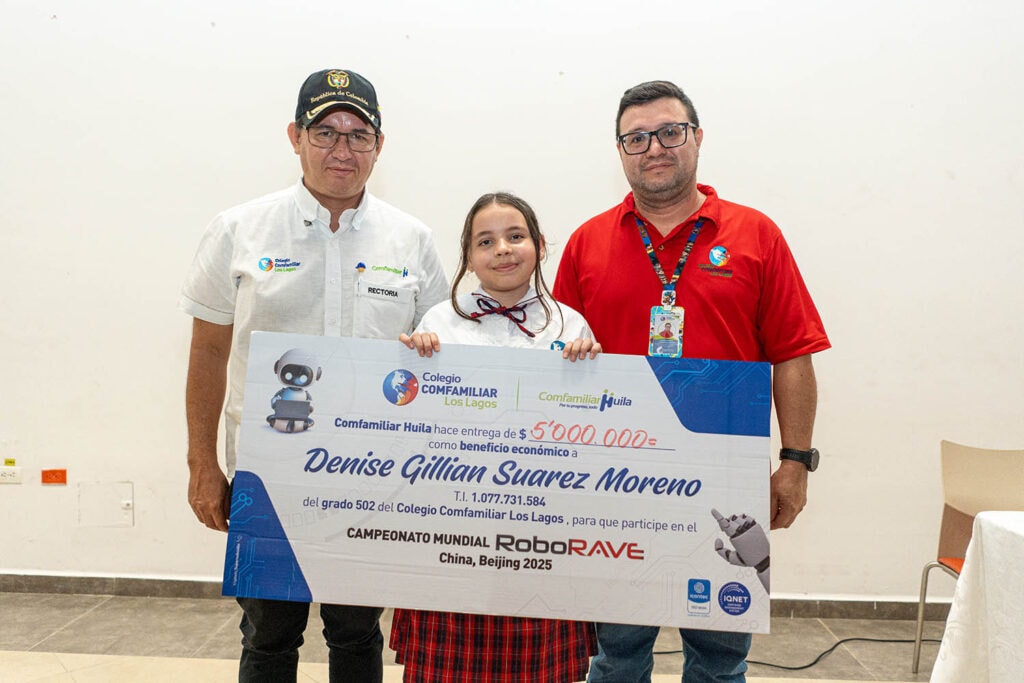 1. Niña recibiendo reconocimiento por su participación en el campeonato mundial RoboRAVE en China, con presencia de representantes de colegio ComFamiliar Huila.