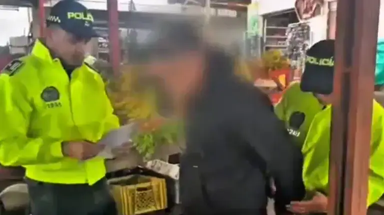 1. Policías de Huila en operación de seguridad en un mercado local, revisando documentación, en un ambiente con vendedores y productos frescos.