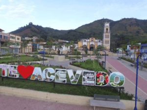 1. Plaza principal de Acevedo, Huila, con belleza natural y arquitectura colonial, rodeada de montañas y decorada con señalizaciones turísticas y flores.