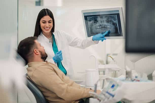 Dentista muestra radiografía dental a paciente en clínica odontológica en Neiva, Huila.
